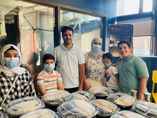 Cooks from Dubai stand with their Supper Club meals.